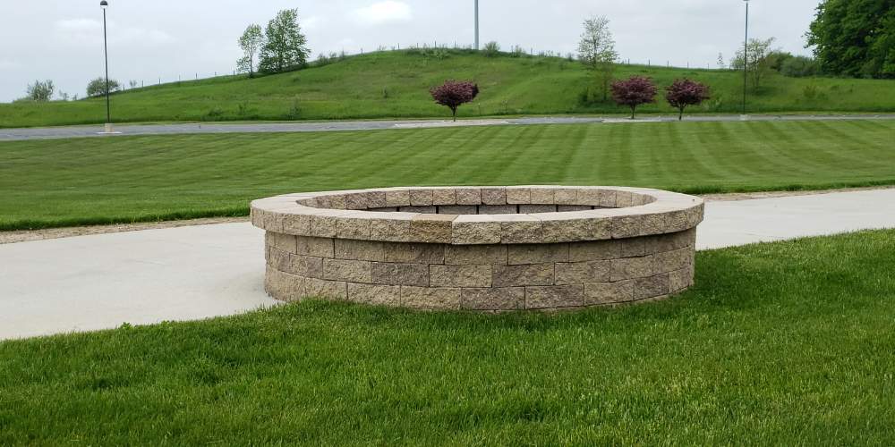 large round firepit with green grass