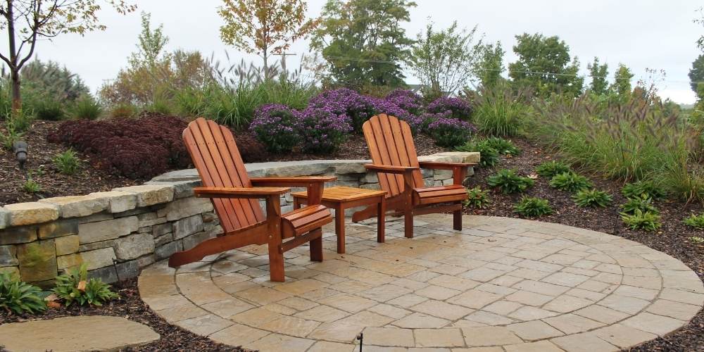 circular patio with chairs and small stone wall