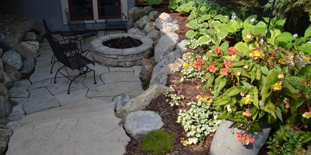 small patio and firepit with plantings