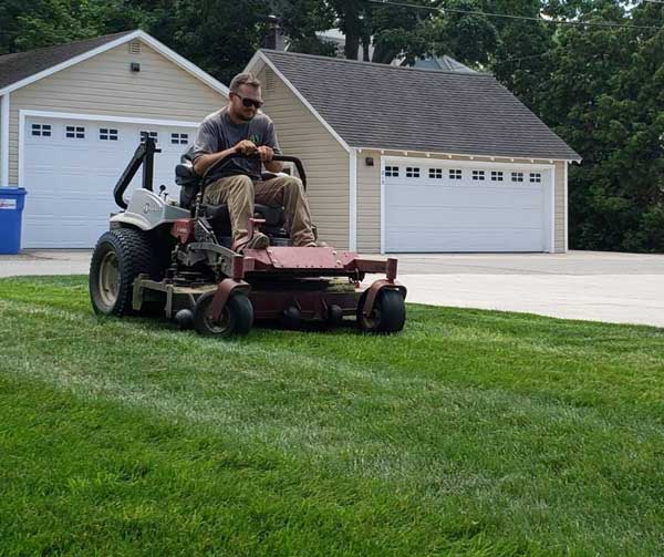 team member mows lawn in northern michigan