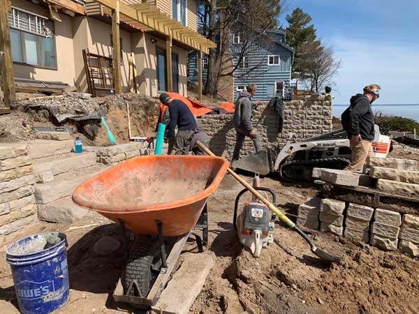 landscape crew installs retaining wall and steps in suttons bay mi