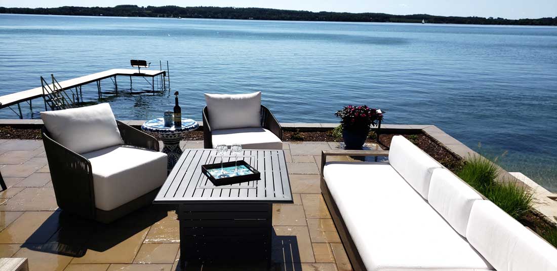 patio with fire table and seating area overlooking suttons bay mi