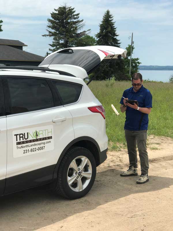 landscape designer takes notes at landscape consultation