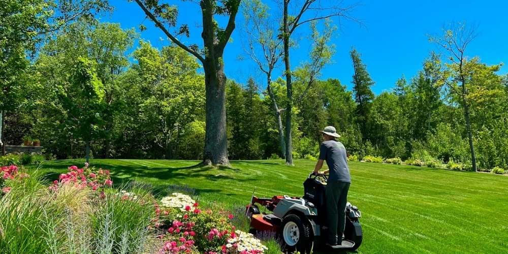 lawn maintenance technician mows lawn with ride-on mower