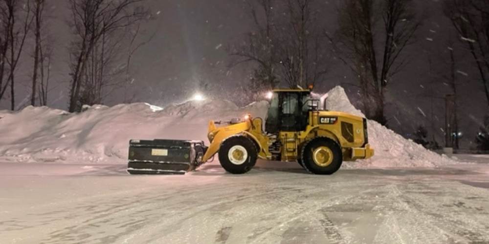 cat 950 loader in front of big pile of snow