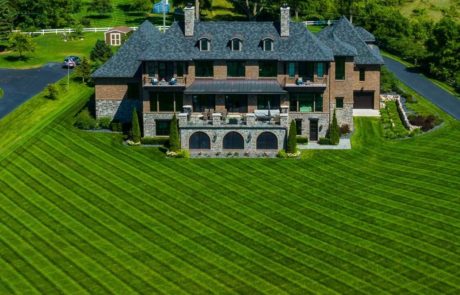 aerial photo of straight mow lines on green grass in front yard of large home