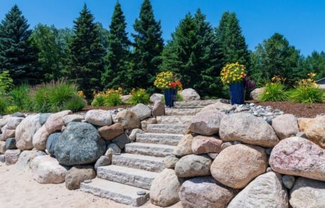 boulder wall with stone steps and plantings