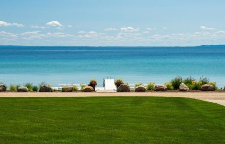 view of lake michigan with healthy green turf and plantings in landscape bed at beach