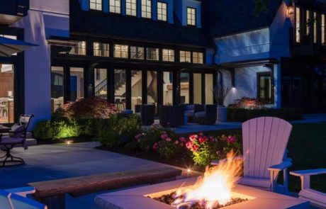 firepit with landscape lighting and limestone patio