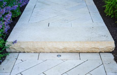 close up of limestone step and walkway in herringbone pattern