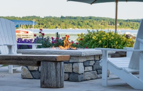 stone fireplace on limestone patio with seating and plantings