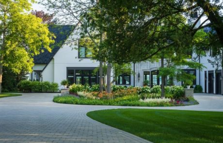 paver driveway and circular drive with flowers and plantings in middle