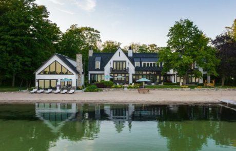 large home on lake with beach and landscaping