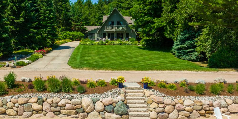 aerial photo of lawn and retaining wall with plantings in landscape bed with mulch