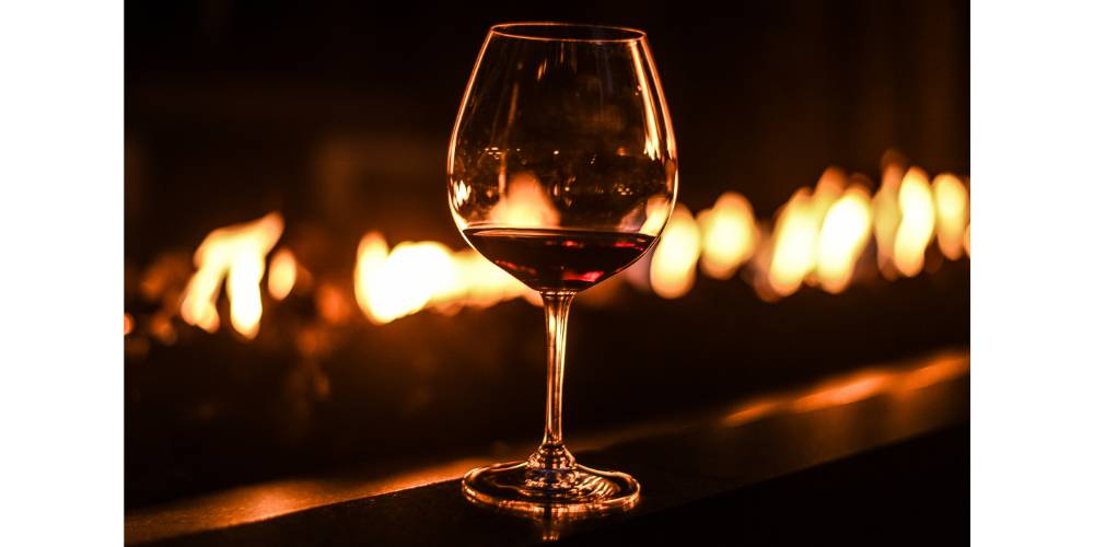 fire table with glass of wine on ledge