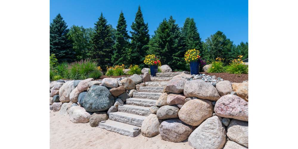 stone steps and boulder wall with plantings at beach