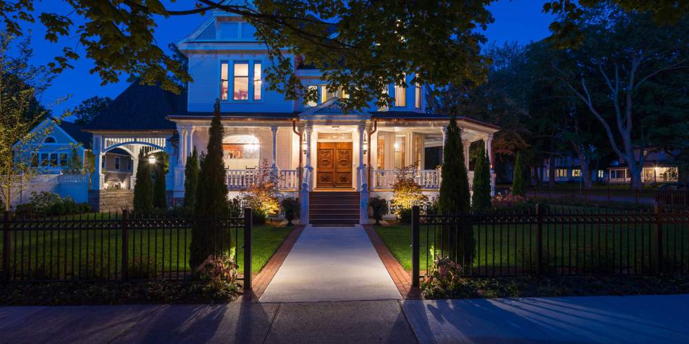 home with landscape lighting and plantings