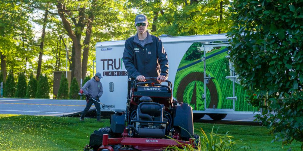 landscape maintenance team mows lawn