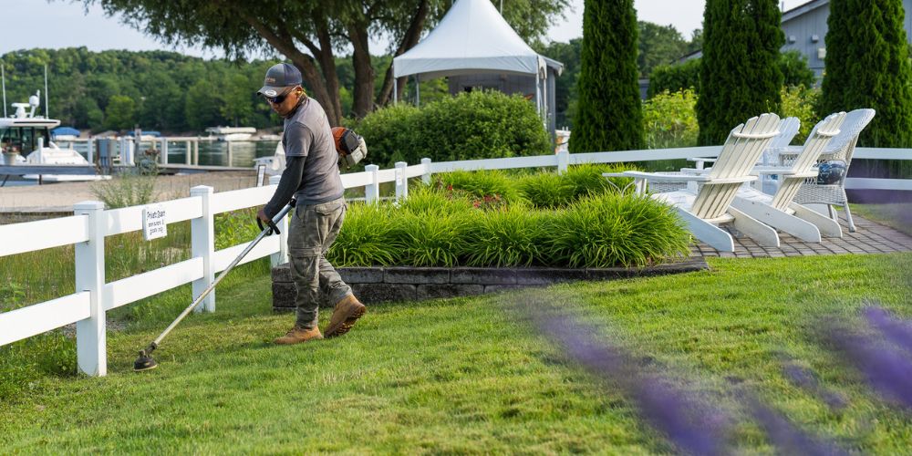 landscape maintenance team trims grass