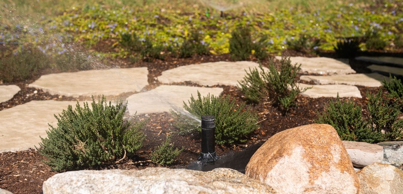irrigation-system-installation-variables-plumbing Underground lawn sprinkler system infrastructure being fitted around existing residential hardscaping.