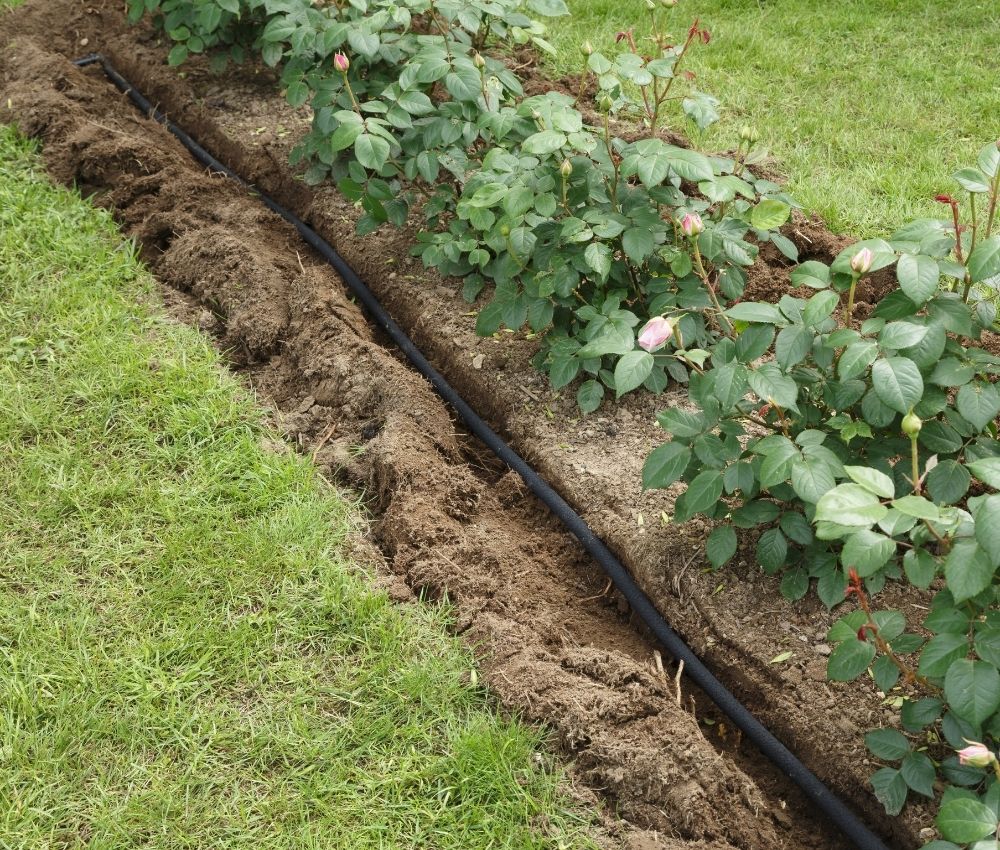 underground-irrigation-pipe-trenching-installation Professional underground irrigation lateral lines and water valves being installed in a freshly dug trench